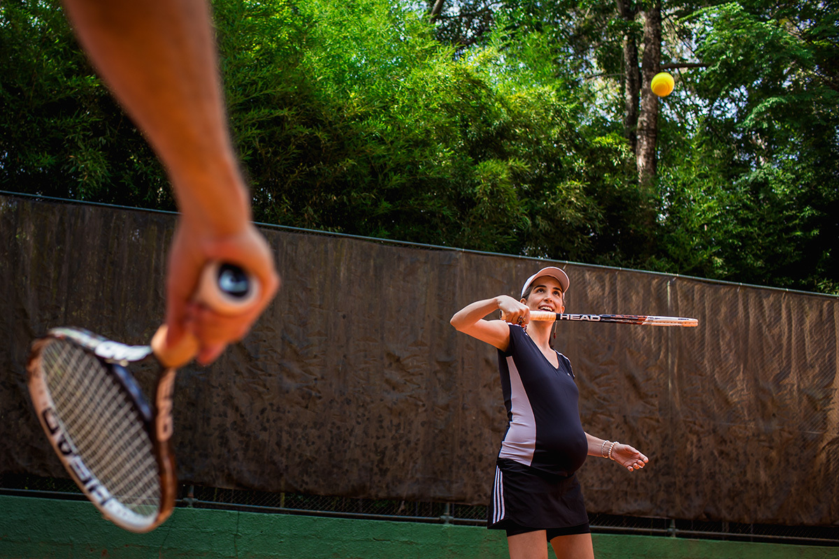 mulher grávida feliz em um jogo de tênis com o marido, por adrianacostafotos