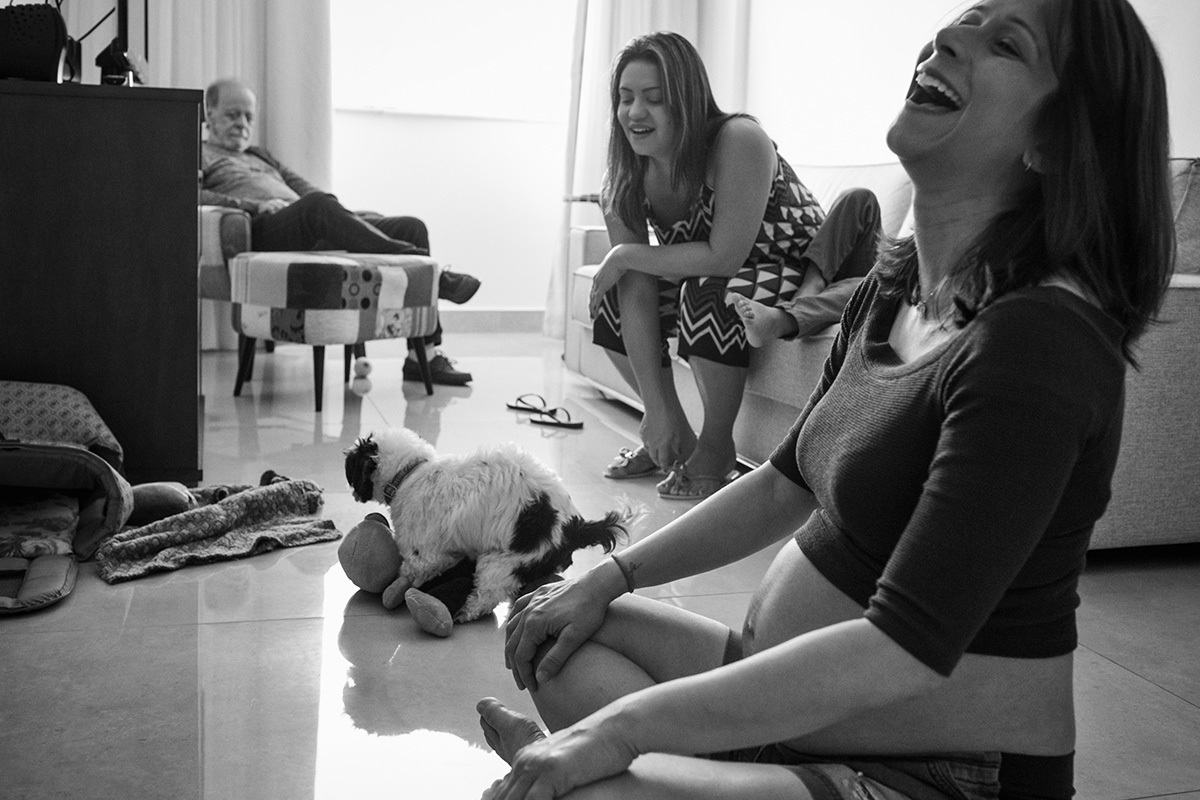 família rindo da cadela que tentava cruzar com o brinquedo