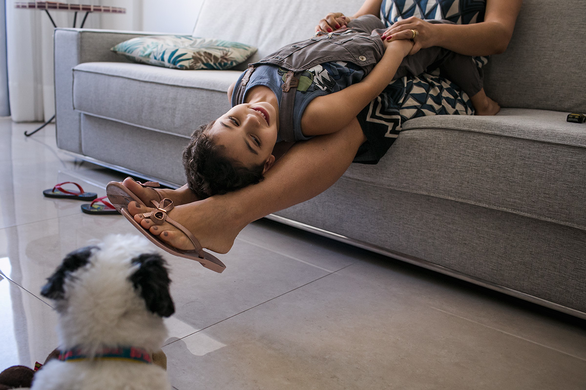 criança brincando com a mãe e a cachorrinha da casa