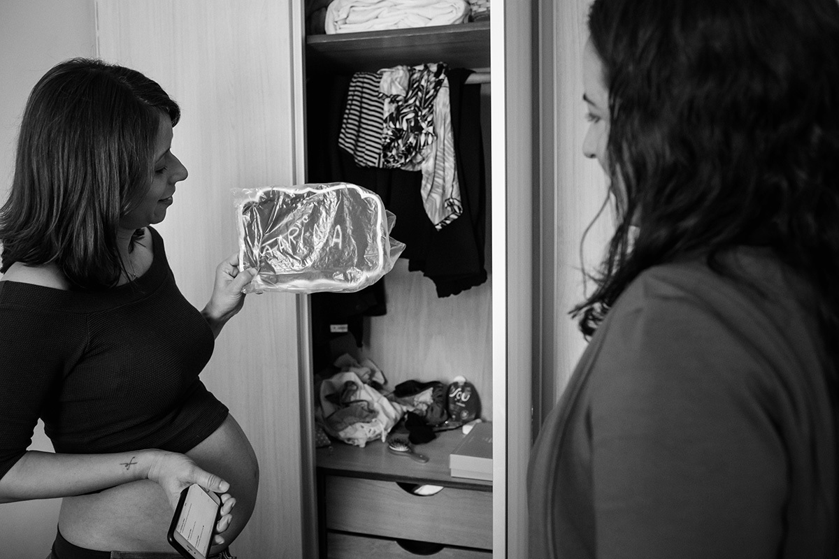 gestante mostrando a amiga o quadro que irá colocar na porta do quarto do bebê