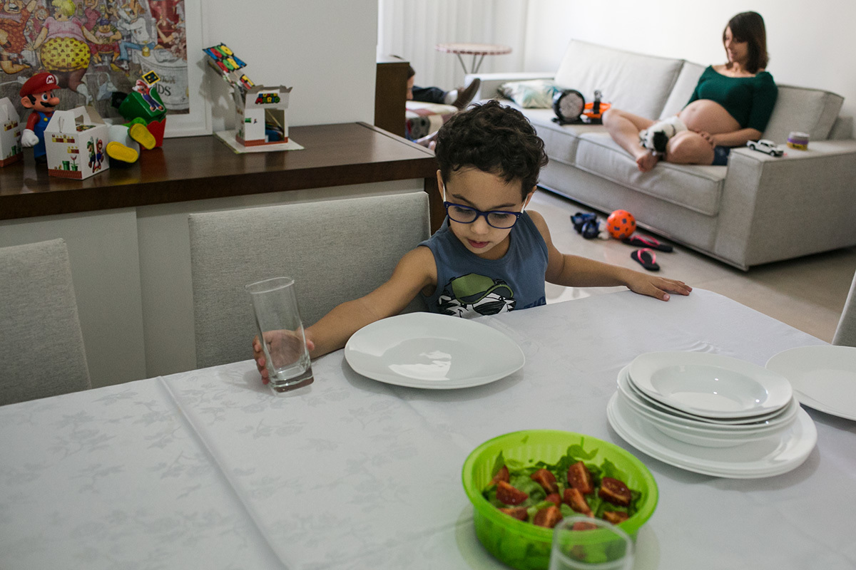 criança ajudando por a mesa de almoço