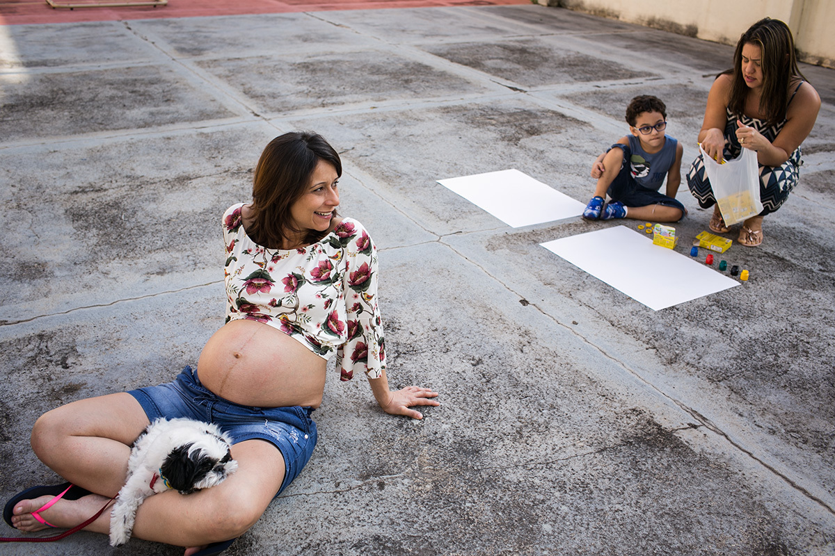 gestante e família com o cachorro da família preparando para fazer pinturas em papel