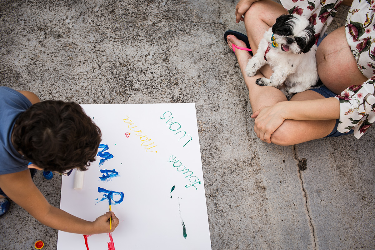 criança pintado no papel o nome da prima que irá nascer