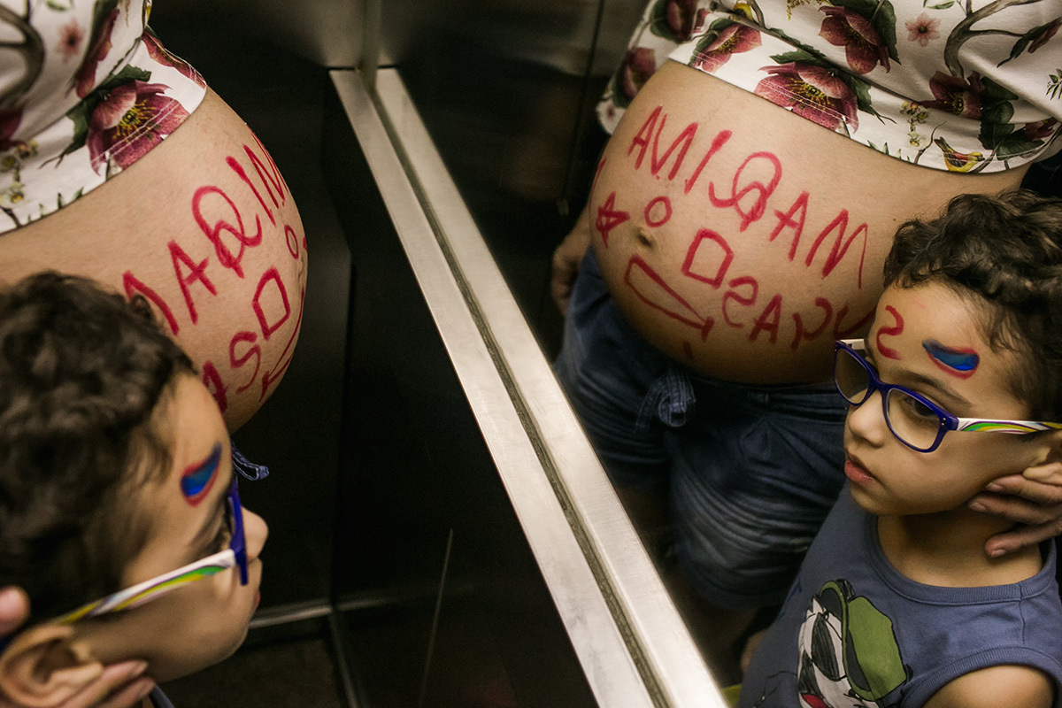 criança e gestante todo sujos de tinta subindo no elevador