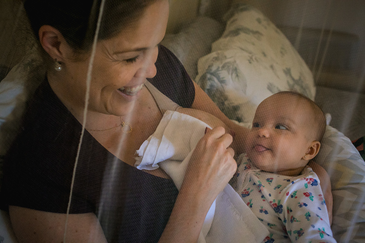 bebê fazendo careta para mãe após amamentar durante um acompanhamento documental feito por Adriana Costa