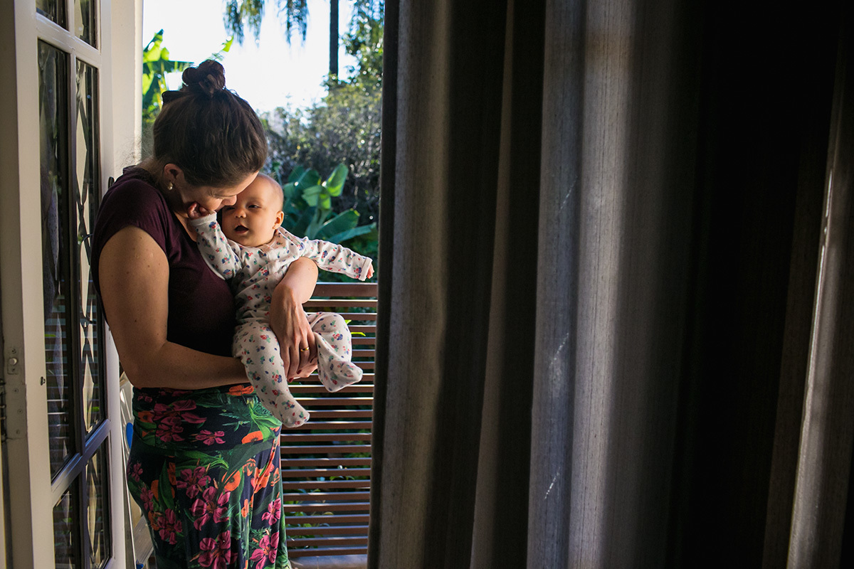 mãe e filha em momento de carinho na varanda da casa, por Adriana Costa
