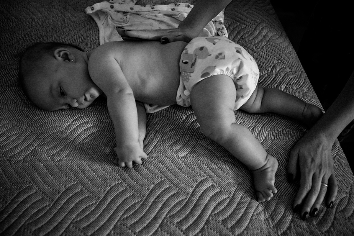 Bebê só com a fralda ecológica se preparando para o banho de sol, por adrianacostafotos