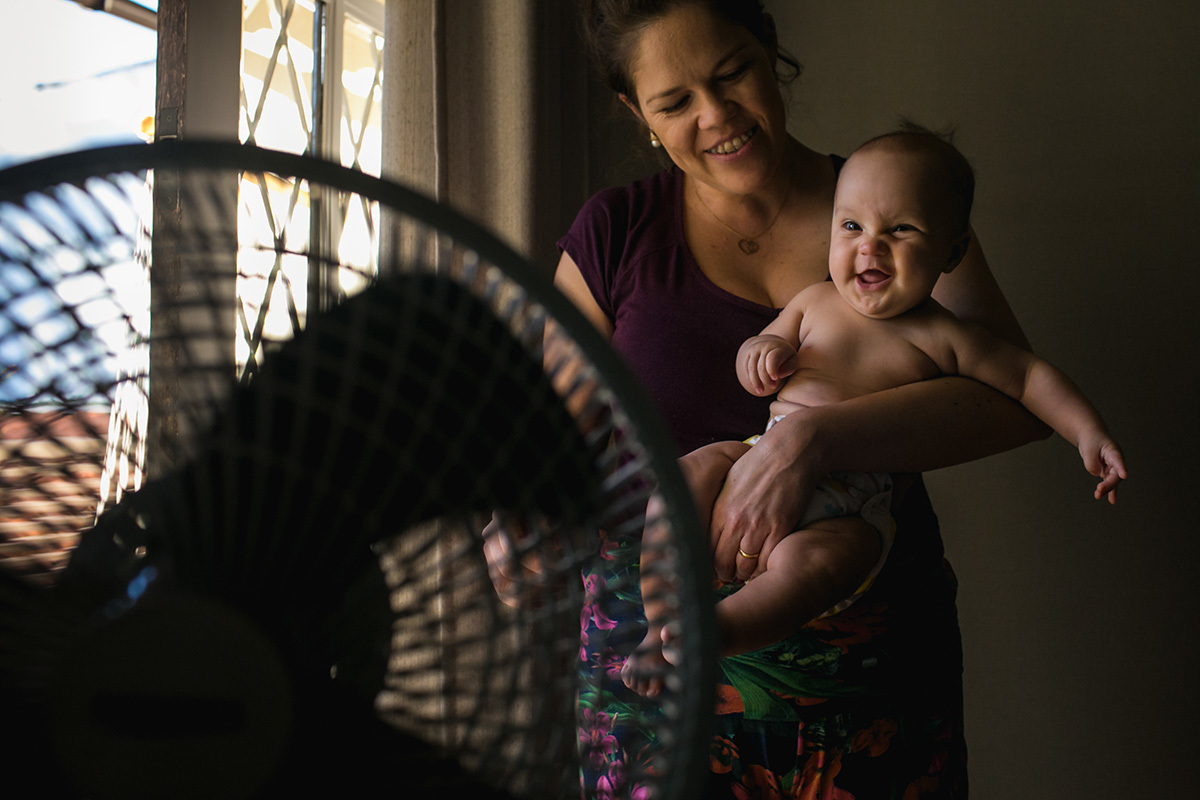foto de Adriana Costa do bebê se divertindo no colo da mãe com o vento do ventilador
