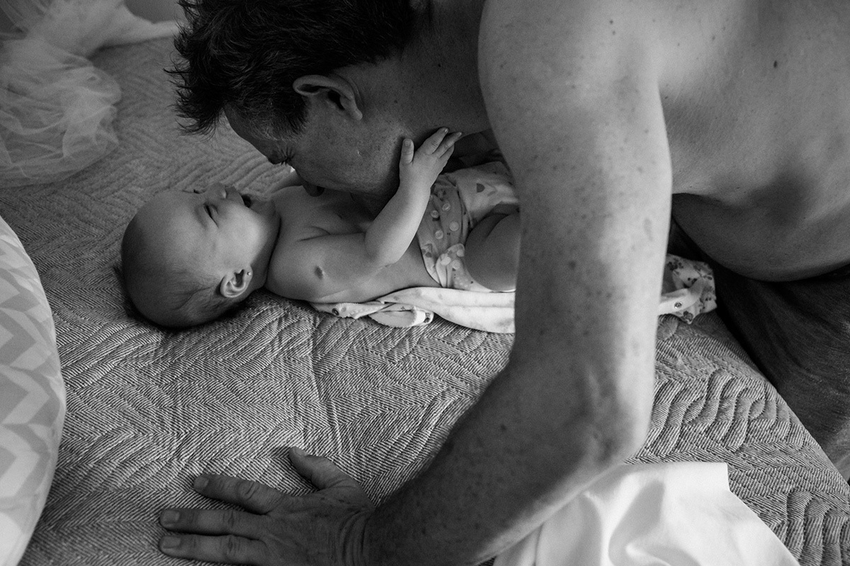 Foto de Adriana Costa do bebê rindo da cocegas feita pelo pai