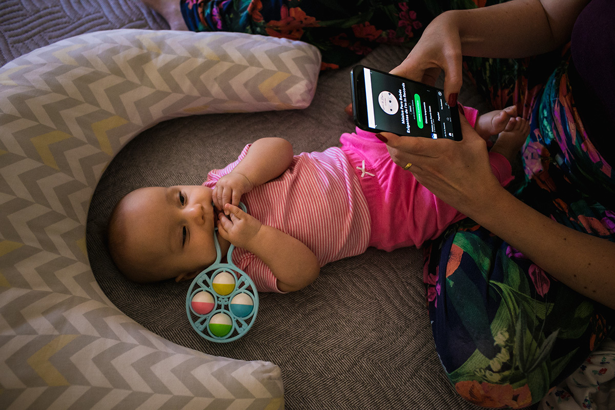 mãe com seu bebê escolhendo música no spotify para o seu bebê dormir, em foto de Adriana Costa