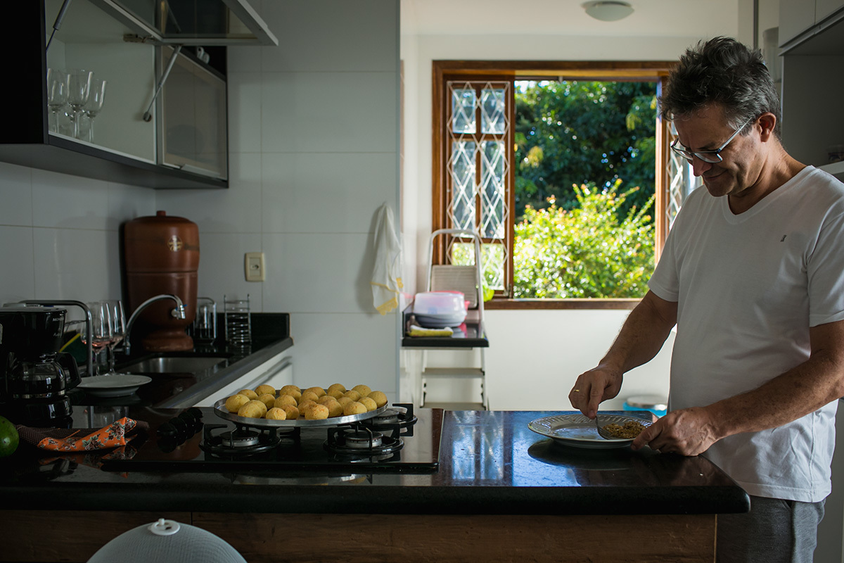 pai preparando o café da manhã com pães de queijo para a família