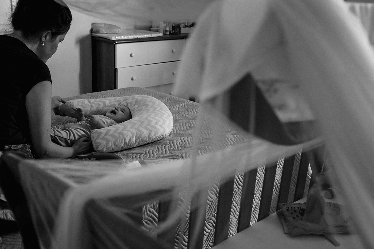 mãe tentando acalmar a sua bebê que chora para dormir