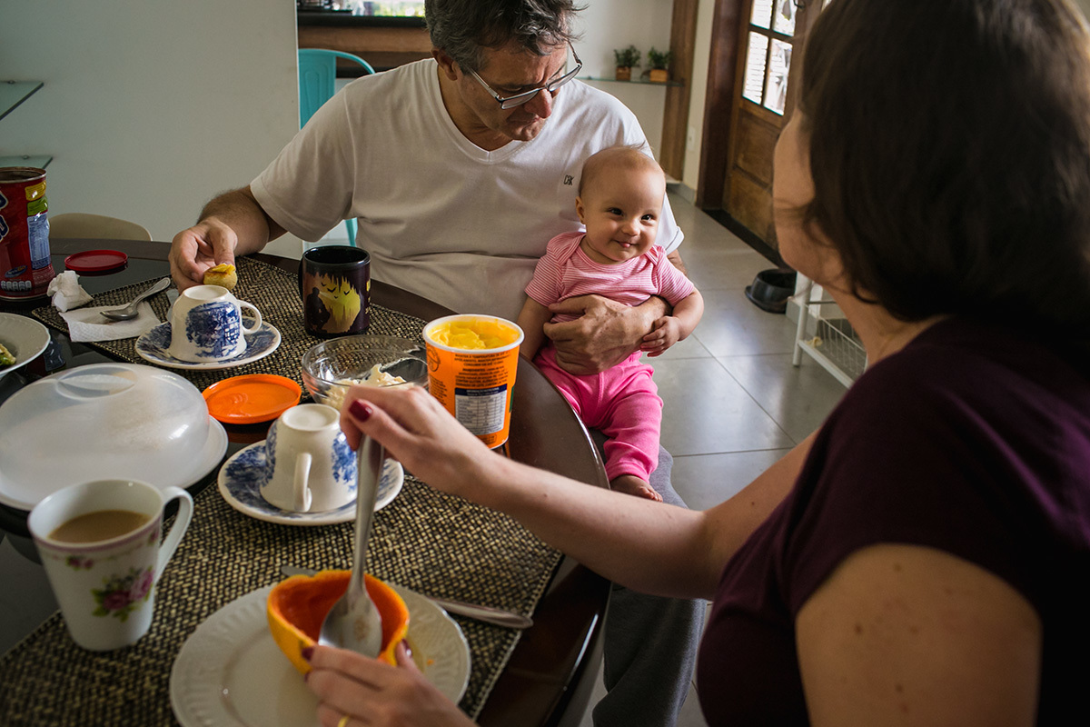 filha no colo do pai pondo língua para a mãe