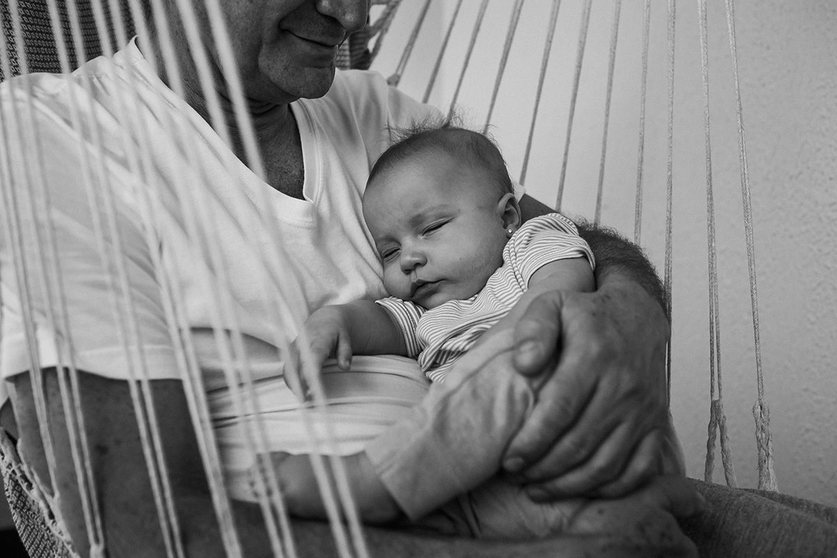 bebê dormindo no colo do pai em foto de Adriana Costa