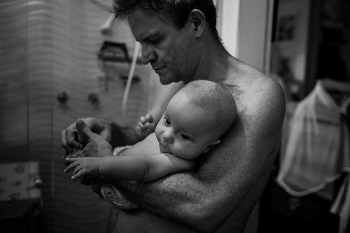 Adriana Costa registrou o pai preparando sua bebê para o banho de chuveiro