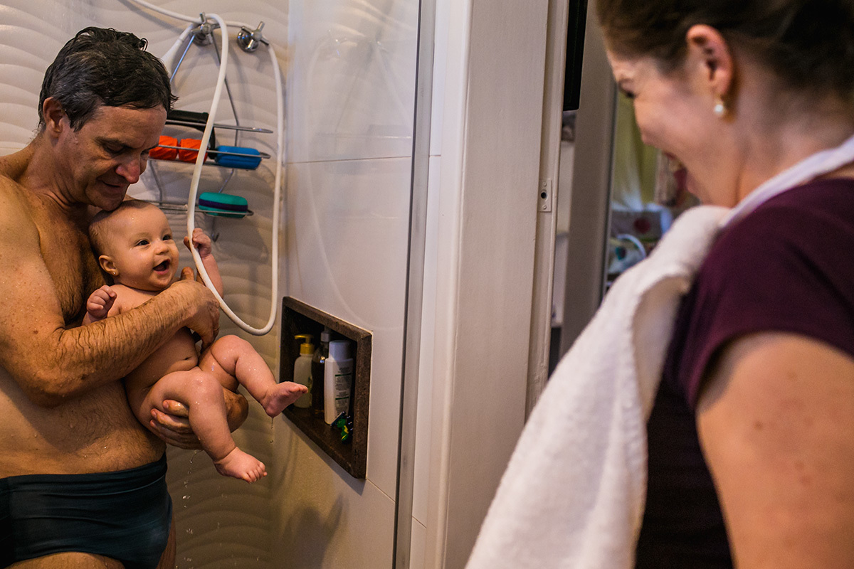bebê sorrindo para a mãe que foi retirá-la do banho