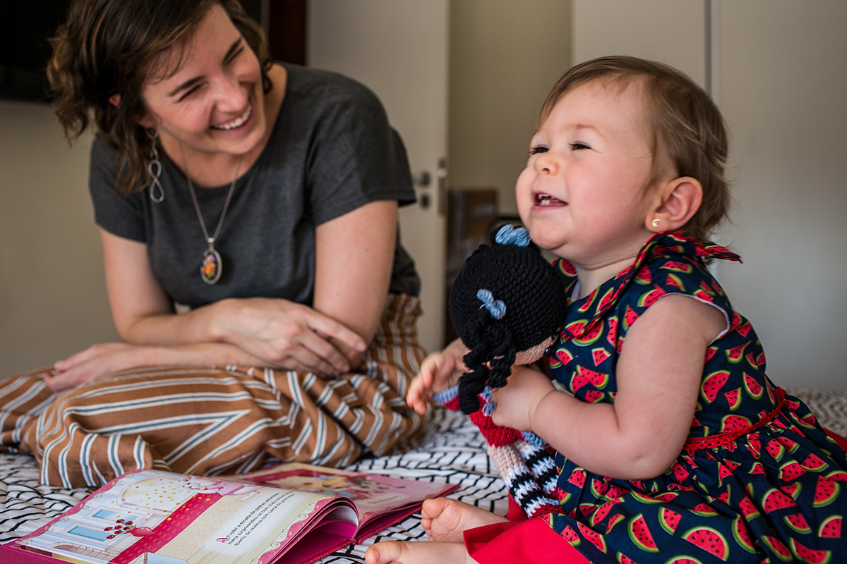 Adriana Costa fotografou mãe rindo do abraço que sua menina deu na boneca