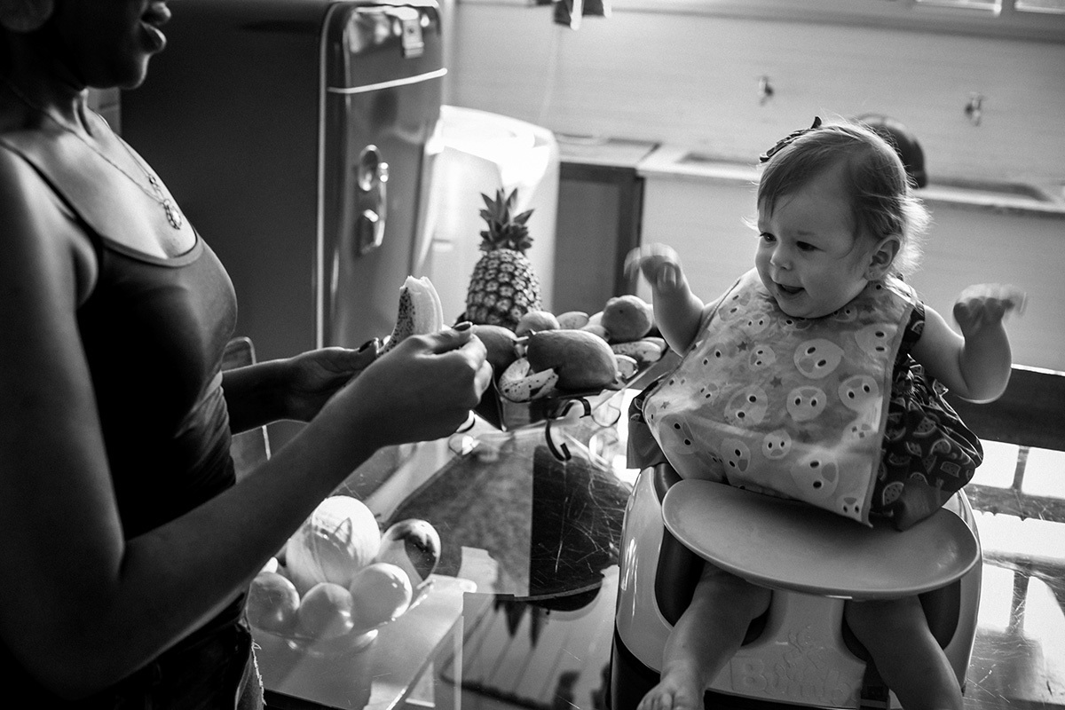 bebê super feliz ao ver a fruta que irá comer, em um registro de Adriana Costa