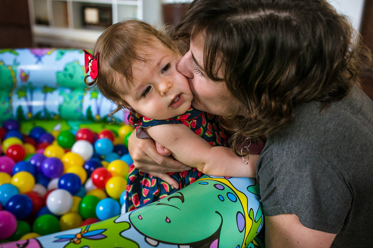 mãe beijando a bochecha da filha