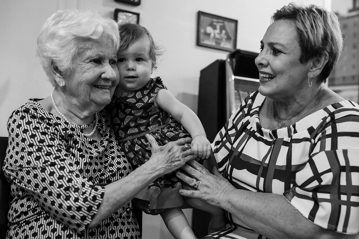 bebê na festa do seu aniversário de um ano com sua avó e bisavó, em foto de Adriana Costa