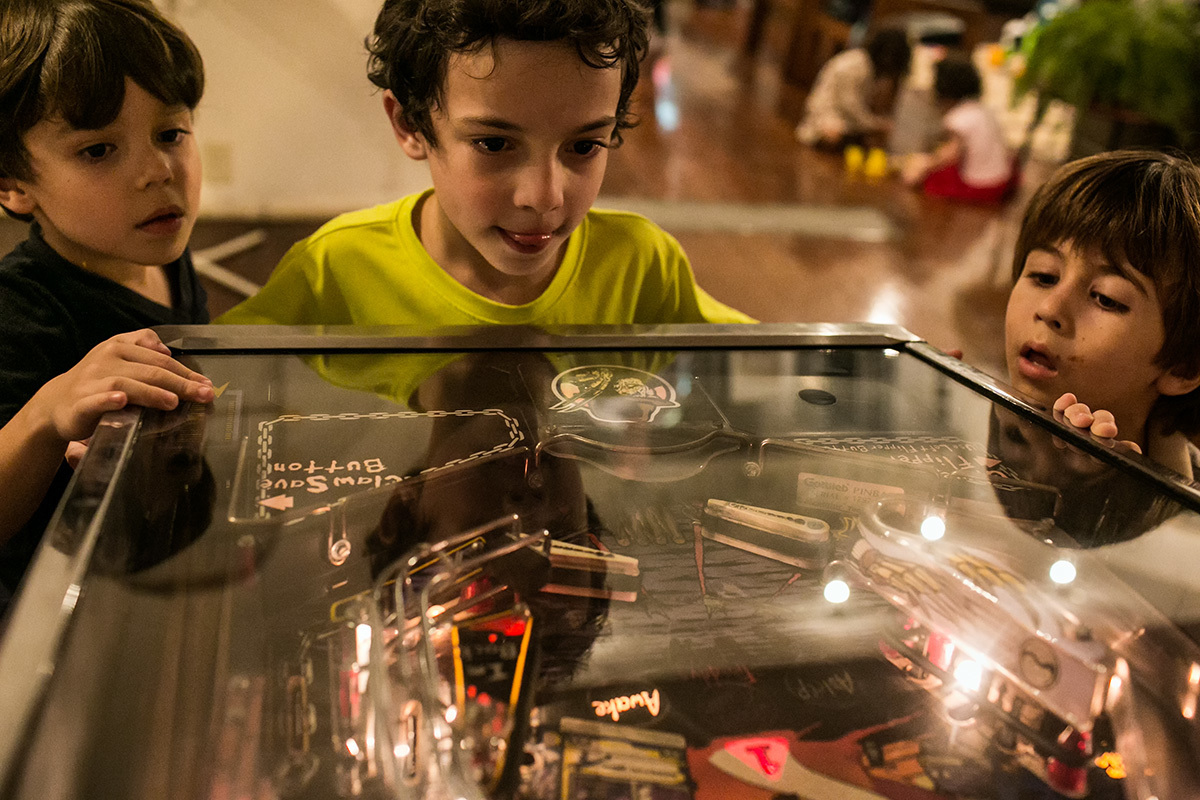 meninos brincando de fliperama durante a festa de aniversário