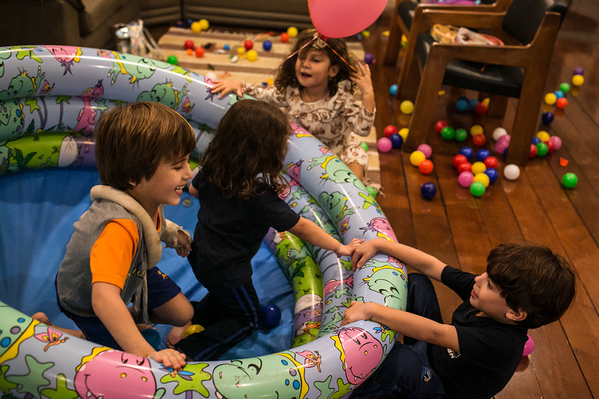 crianças virando a piscina de bolinha durante uma brincadeira