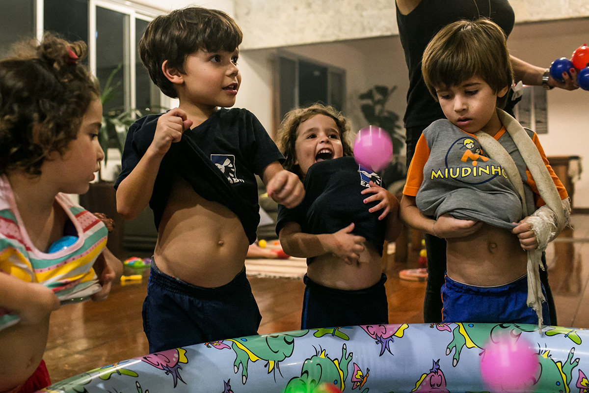 Crianças devolvendo as bolinhas que estavam dentro de suas roupas para piscina de bolinhas, em foto de Adriana Costa