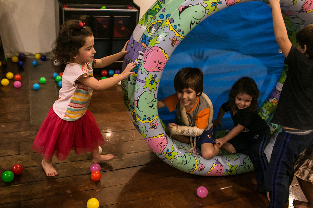 Foto de Adriana Costa de crianças usando uma piscina de bolinha como uma nova brincadeira: como roda para girar com crianças dentro