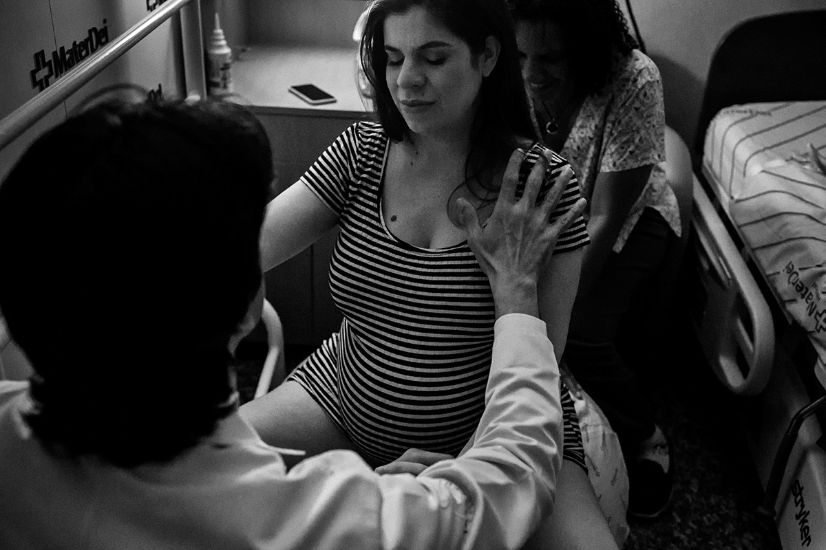 obstetra e doula acalmando a gestante durante uma contração do parto