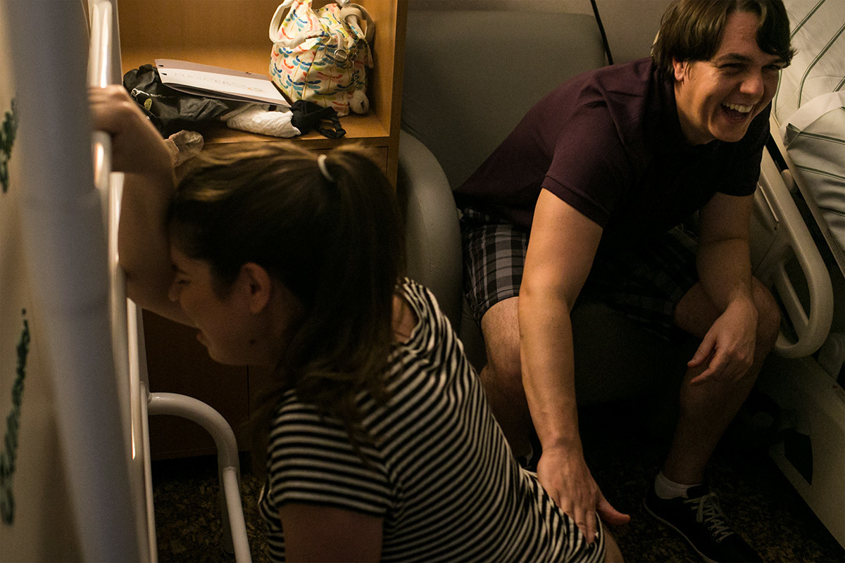 marido alegre massageando a esposa durante a contração do trabalho de parto, por Adriana Costa