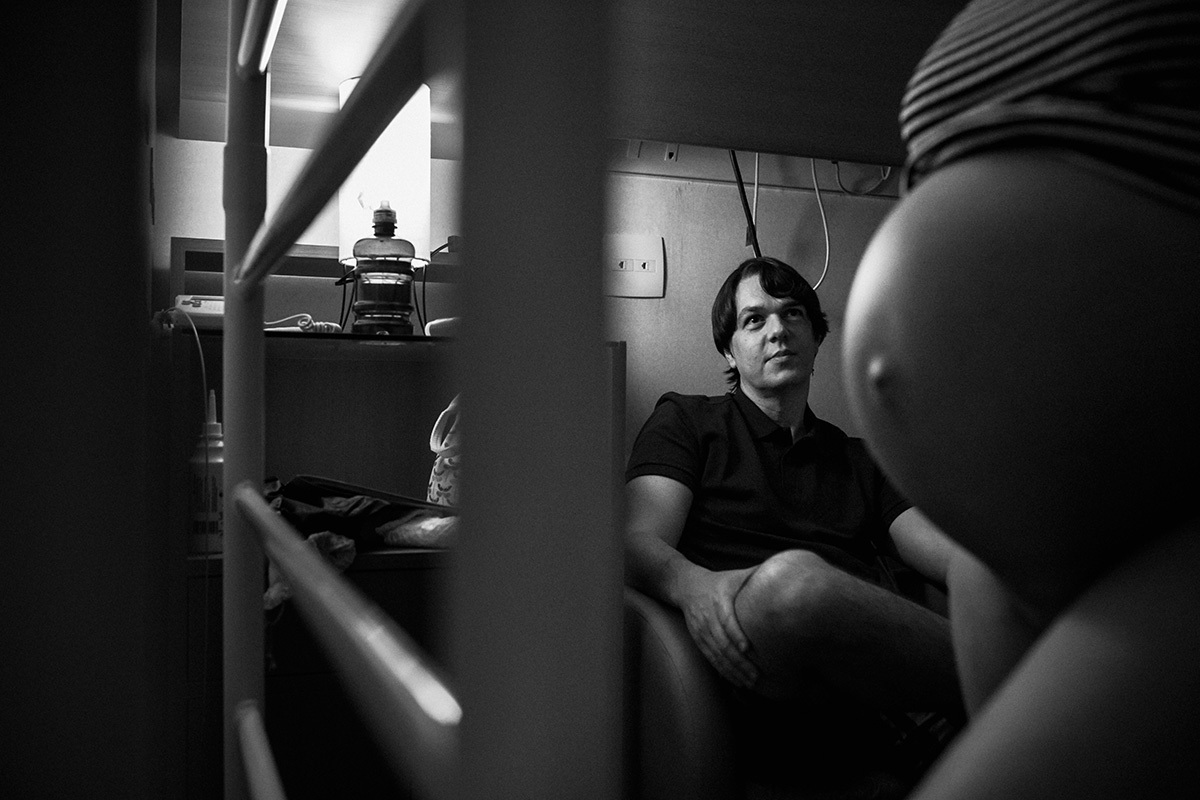 marido observando a barriga da esposa durante o trabalho de parto, por Adriana Costa