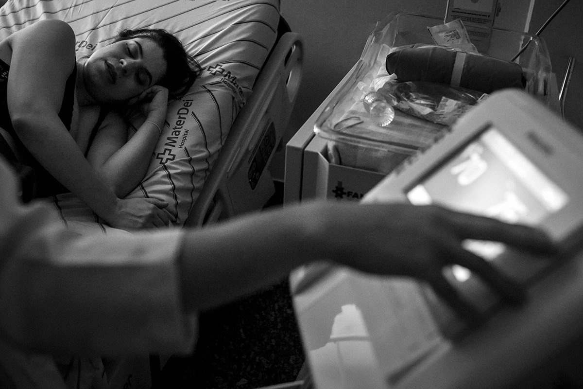 enfermeira conferindo batimentos cardíacos do bebê enquanto a parturiente descansa do trabalho de parto