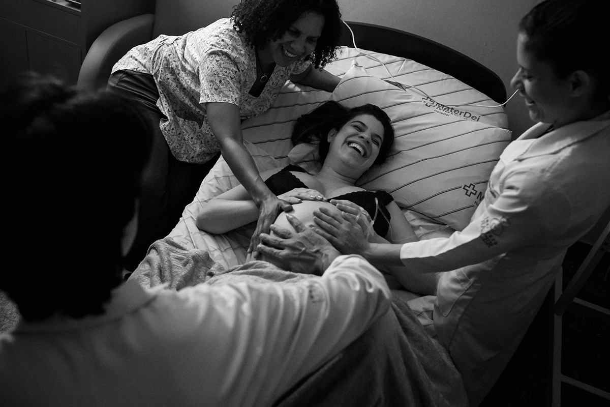 foto de Adriana Costa da parturiente em um lindo momento sendo abençoada pela equipe que a acompanha, equipe do Instituto Nascer