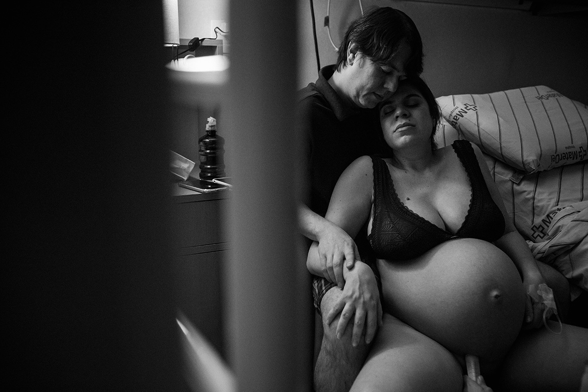 casal descansando jundos durante o trabalho de parto, na maternidade Mater Dei de BH, em foto de Adriana Costa