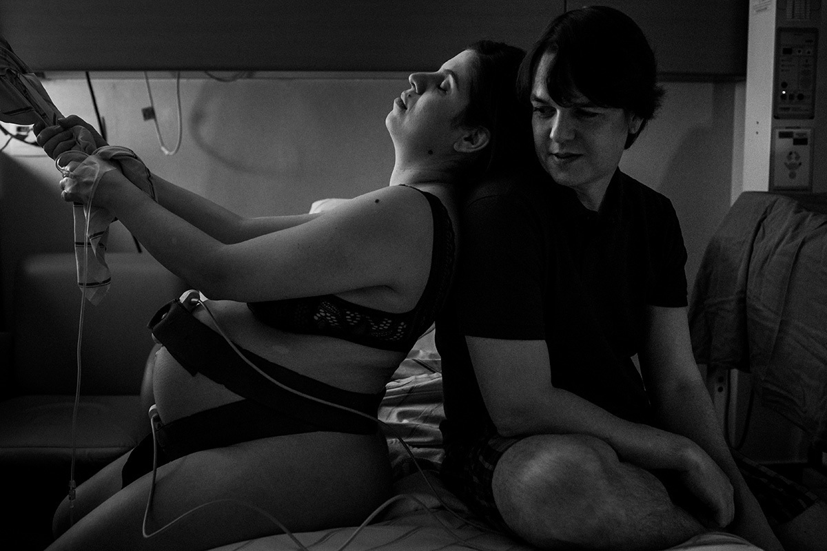 parturiente apoiada no rebozo amarrado na Escada de Ling e apoiada nas costas do marido, por Adriana Costa