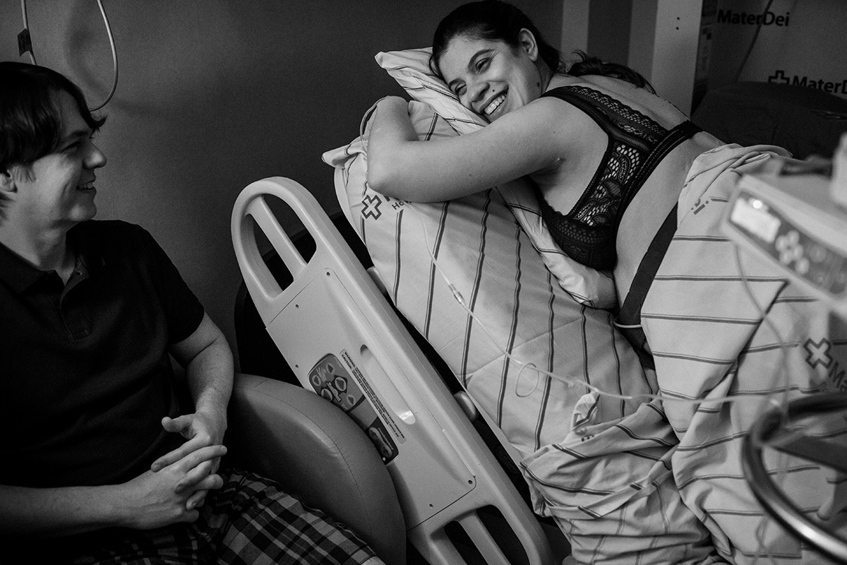 gestante descansando apoiada de quatro durante o trabalho de parto ao lado de seu marido