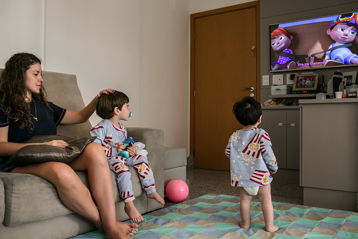 Renata Lucena assiste TV com dois de seus filhos
