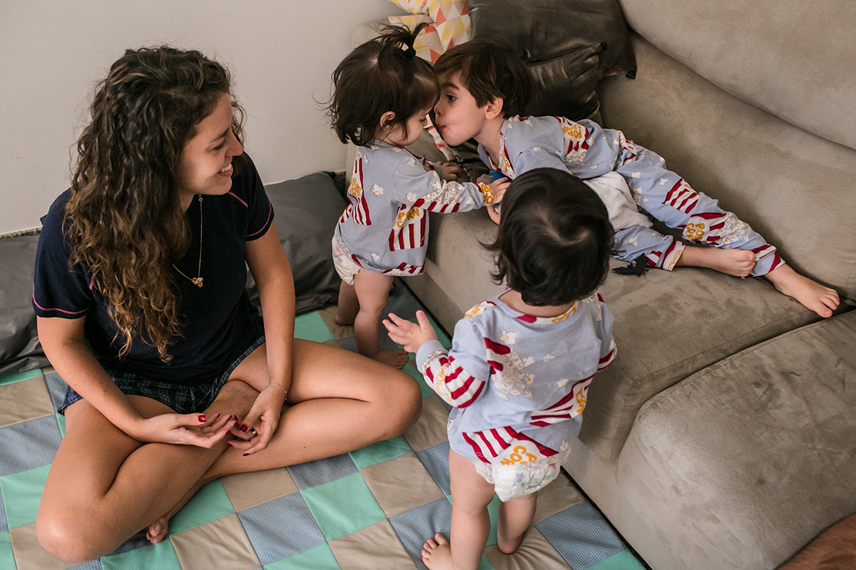 Renata Lucena observa Rafinha sendo carinhoso com suas irmãs gêmeas, em foto de Adriana Costa