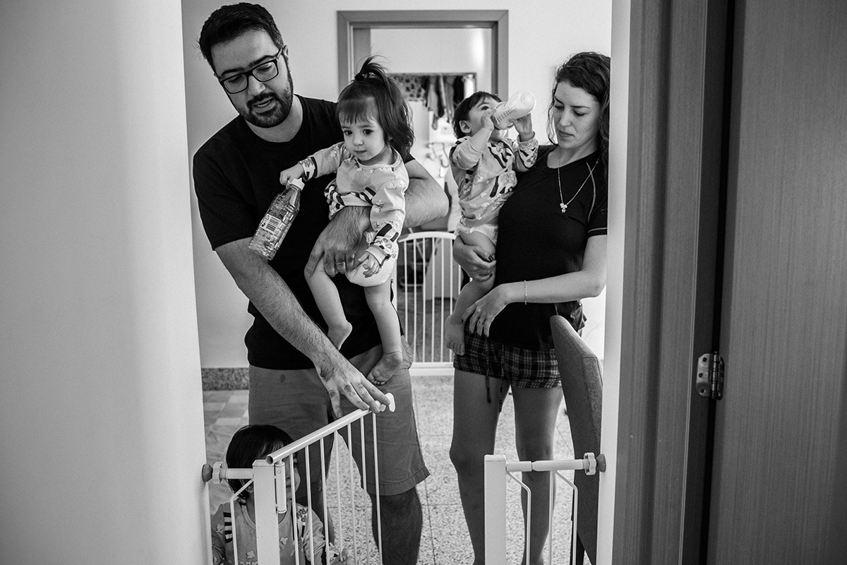 Renata Lucena e seu marido carregam seus trigêmeos para o quarto, por Adriana costa