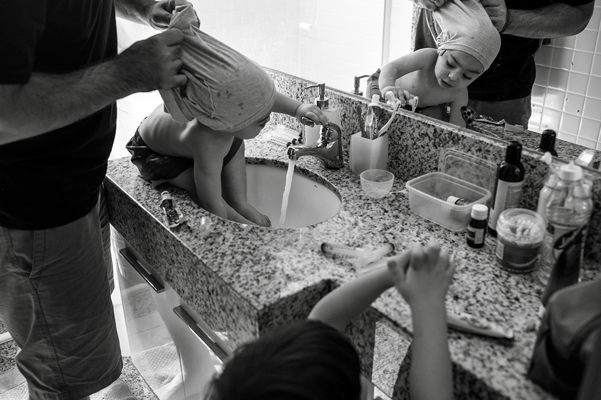 pai prepara um de seus trigêmeos para o banho