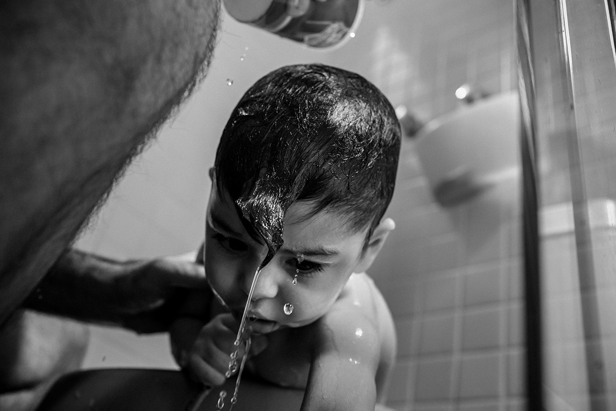 Adriana Costa fotografou gotas de água escorrendo da cabeça do bebê enquanto o pai lava a cabeça dele no banho