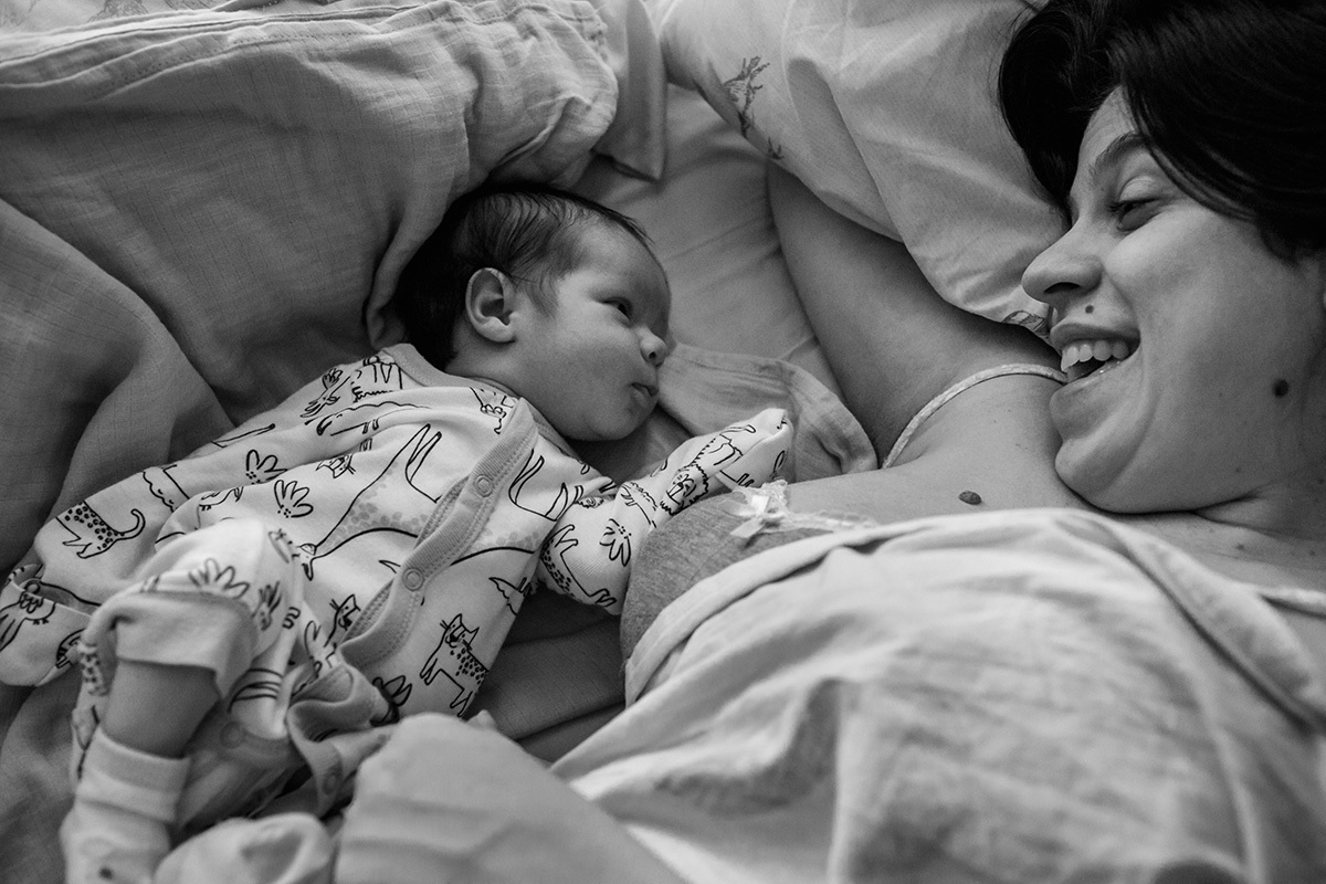 Adriana Costa registrou mãe na cama sorrindo para seu bebê após amamentá-lo