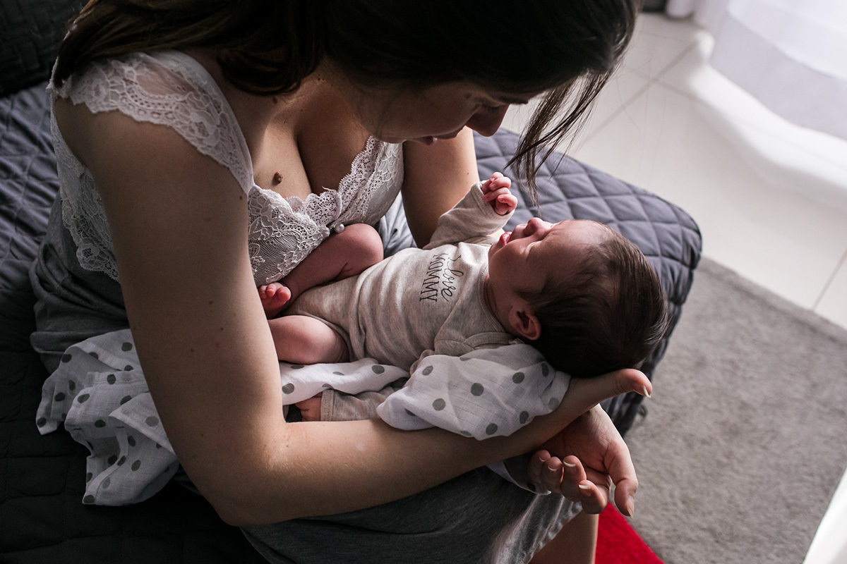 mãe tenta acalmar seu bebê que chora