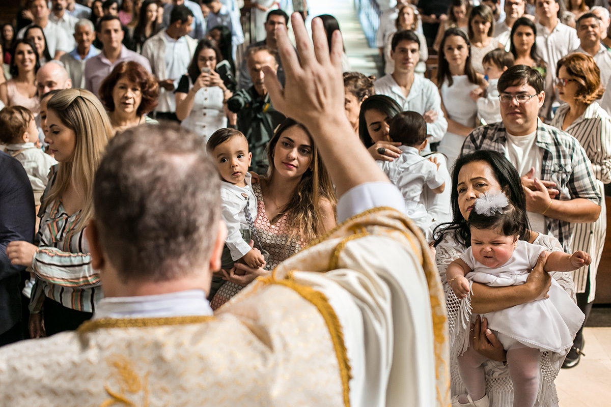 padre abençoando todas as crianças que foram na missa de batismo