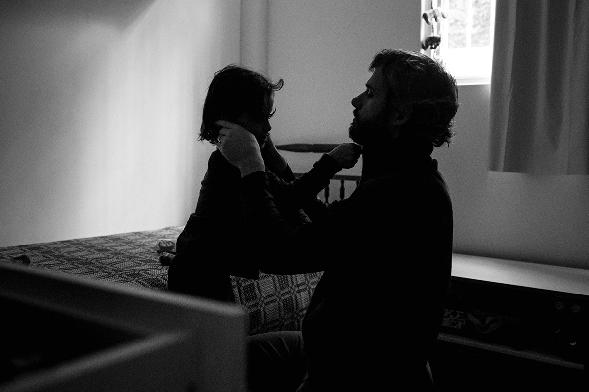 pai cuidando do filho em casa no dia do nascimento do seu caçula