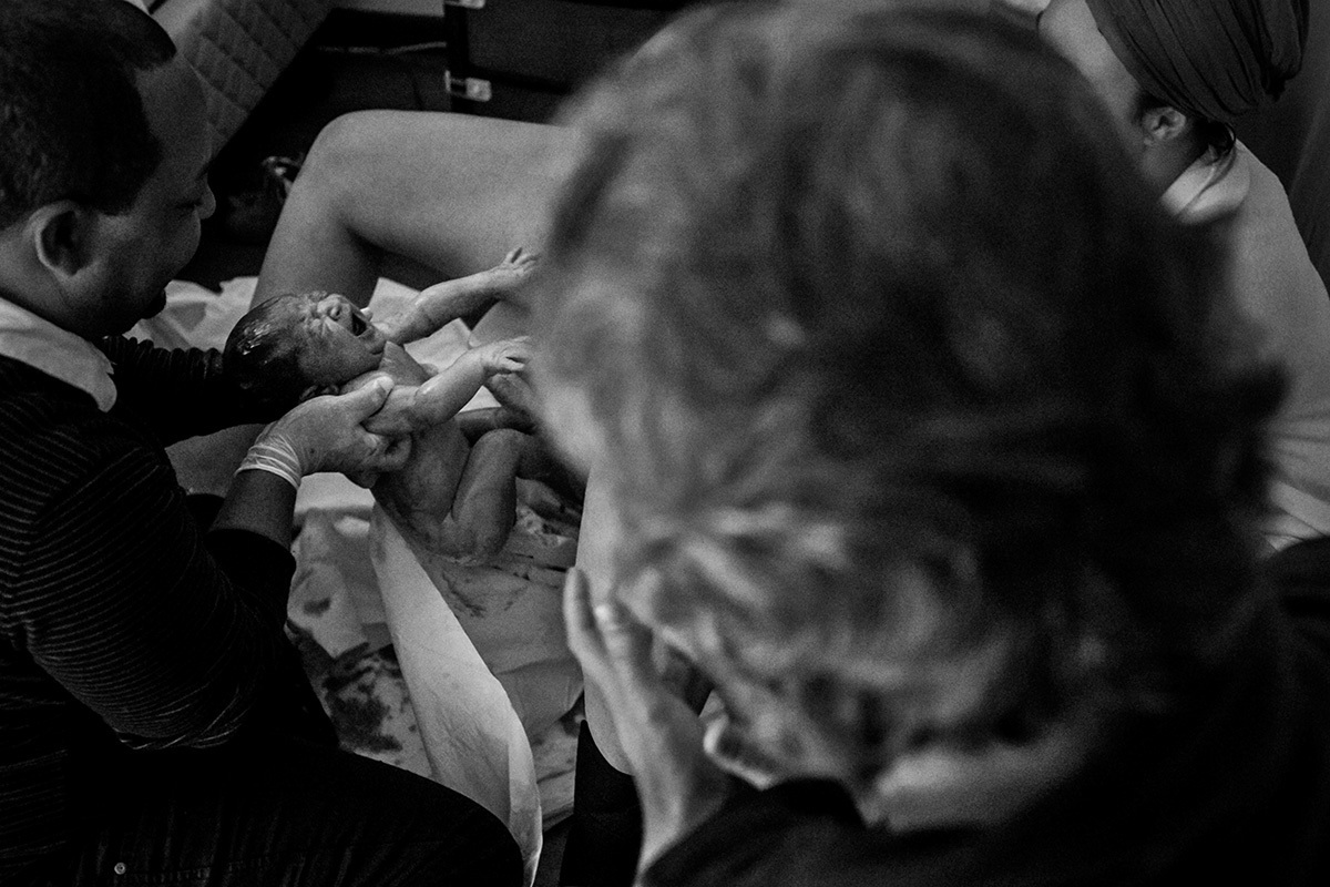 pai observa seu filho nascendo em casa, por Adriana Costa