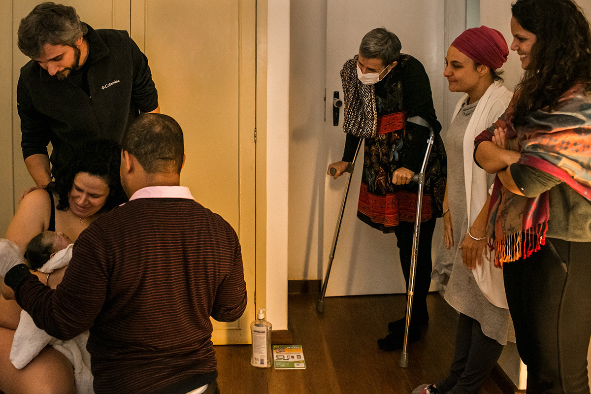 equipe de assistência ao parto observa a família que acabou de ter o bebê