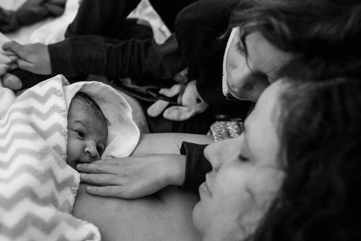 menino ajuda seu irmão que acabou de nascer a amamentar