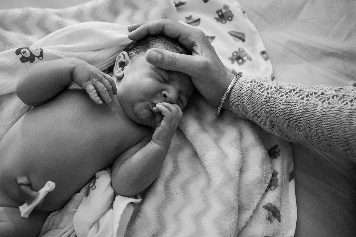 mãe fazendo carinho em seu bebê durante seu primeiro exame pós-parto