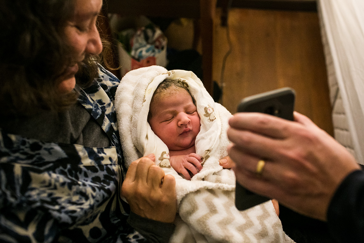 pai mostra seu filho que acabou de nascer para sua mãe via skype